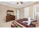 Comfortable bedroom with a dresser, closet, and bed with decorative pillows and linens at 42109 N Astoria Way, Anthem, AZ 85086