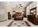 Bright main bedroom with a seating area, detailed ceiling fan, and decorative glass block accent wall at 42109 N Astoria Way, Anthem, AZ 85086