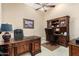 Home office featuring a dark wood desk, leather chairs, built-in shelves, and a comfortable workspace at 42109 N Astoria Way, Anthem, AZ 85086