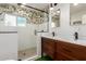Stylish bathroom featuring a glass shower, wood vanity, and tropical wallpaper at 430 N Vineyard --, Mesa, AZ 85201