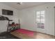 Well-lit exercise room with tiled floors, television, and weights adjacent to an exterior door at 430 N Vineyard --, Mesa, AZ 85201