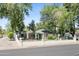 Single story home with a vibrant green lawn, white fence, and mature shade trees at 430 N Vineyard --, Mesa, AZ 85201