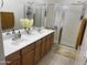Bathroom with double sink vanity, wooden cabinets, decorative towels and shower with glass door at 44899 W Portabello Rd, Maricopa, AZ 85139