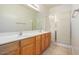 Spacious bathroom featuring a double vanity with wood cabinets and a glass-enclosed shower at 44899 W Portabello Rd, Maricopa, AZ 85139