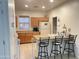 Bright kitchen featuring wooden cabinets, tiled floor, and a breakfast bar with bar stools at 44899 W Portabello Rd, Maricopa, AZ 85139