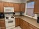 Well-lit kitchen featuring wooden cabinets, a white stove, and plenty of counter space at 44899 W Portabello Rd, Maricopa, AZ 85139
