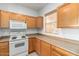 This kitchen is equipped with wooden cabinets, a microwave, and a smooth top stove at 44899 W Portabello Rd, Maricopa, AZ 85139