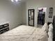 Bedroom featuring neutral bedding, mirror, open closet with organized clothing, crib and decor at 44899 W Portabello Rd, Maricopa, AZ 85139