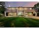 Expansive back exterior with a covered patio, large windows, and lush green lawn at 4494 E Reins Rd, Gilbert, AZ 85297