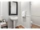 Elegant powder room featuring a pedestal sink with dark-framed mirror and neutral tile floors at 4494 E Reins Rd, Gilbert, AZ 85297