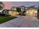 Stunning front exterior featuring a large driveway leading to three garages and beautiful desert landscaping at 4494 E Reins Rd, Gilbert, AZ 85297