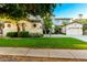 Well-maintained home with a lush lawn, mature trees, and a three car garage at 4494 E Reins Rd, Gilbert, AZ 85297