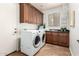 Well-organized laundry room featuring cabinetry, sink, and modern washer and dryer at 4494 E Reins Rd, Gilbert, AZ 85297