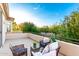 Relaxing covered patio area with cushioned wicker furniture and lush landscaping with a street view at 4494 E Reins Rd, Gilbert, AZ 85297