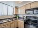 Well-equipped kitchen featuring stainless steel sink and black oven microwave appliances at 4925 E Desert Cove Ave # 326, Scottsdale, AZ 85254