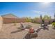 The backyard boasts a well-manicured lawn, a fire pit, seating area, and beautiful desert landscaping at 5079 E Emery Rd, San Tan Valley, AZ 85143