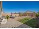 The backyard boasts a well-manicured lawn, a seating area, and beautiful desert landscaping at 5079 E Emery Rd, San Tan Valley, AZ 85143