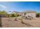 The backyard boasts a well-manicured lawn, a seating area, and beautiful desert landscaping at 5079 E Emery Rd, San Tan Valley, AZ 85143