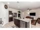 Stylish kitchen island with stainless steel dishwasher and a view of the living room's fireplace at 5079 E Emery Rd, San Tan Valley, AZ 85143