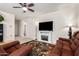 Cozy living room with a decorative fireplace, flat-screen TV, and comfortable leather seating on a tiled floor at 5079 E Emery Rd, San Tan Valley, AZ 85143