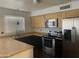 Modern kitchen featuring stainless steel appliances, light wood cabinets, and dark countertops, creating a stylish and functional space at 5708 S Beck Ave, Tempe, AZ 85283