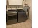 Well-equipped laundry room featuring modern washer and dryer, along with storage cabinets and a water heater at 5708 S Beck Ave, Tempe, AZ 85283