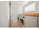 Well-lit laundry room featuring modern washer and dryer units, wood countertops, and white cabinetry at 5812 N 18Th Pl, Phoenix, AZ 85016