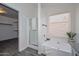 Bathroom with bathtub, a separate shower, and a window for natural light with a walk-in closet at 6623 N 85Th Ave, Glendale, AZ 85305