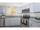 Kitchen features stainless steel appliances, granite countertops, and blue cabinets at 6623 N 85Th Ave, Glendale, AZ 85305