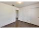 Bedroom with hardwood floors and a closet featuring doors and an open entrance at 6830 W Desert Ln, Laveen, AZ 85339