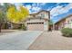 Two-story home with a large driveway and an attached two-car garage with a beige exterior at 6830 W Desert Ln, Laveen, AZ 85339