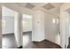 Bright hallway featuring hardwood floors and access to multiple rooms with natural light at 6830 W Desert Ln, Laveen, AZ 85339