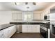 Modern kitchen featuring stainless steel appliances and white cabinetry, with hardwood floors at 6830 W Desert Ln, Laveen, AZ 85339