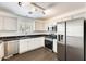 Bright kitchen with white cabinets, stainless steel appliances, and dark countertops at 6830 W Desert Ln, Laveen, AZ 85339