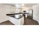Modern kitchen with white cabinets, stainless steel appliances, and sleek black countertops at 6830 W Desert Ln, Laveen, AZ 85339