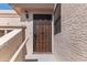 Close-up of a secure front door with a decorative metal screen and an exterior light fixture at 7800 E Lincoln Dr # 2092, Scottsdale, AZ 85250