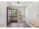 Bright living room featuring tile floors, ceiling fan, and access to the outdoor balcony through a glass door at 7800 E Lincoln Dr # 2092, Scottsdale, AZ 85250