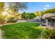 Lush backyard with a pool, multiple seating areas, and manicured lawn at 9087 E Mountain Spring Rd, Scottsdale, AZ 85255