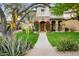 Charming home with a stone archway, lush landscaping and walkway leading to the front door at 9087 E Mountain Spring Rd, Scottsdale, AZ 85255
