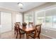 Dining room with a wooden table and chairs, tile floors, and natural light at 9662 W Sunnyslope Ln, Peoria, AZ 85345