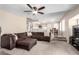 Living room featuring sofa, ceiling fan, view into the kitchen, and dining space at 9662 W Sunnyslope Ln, Peoria, AZ 85345