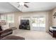 Living room with ceiling fan, carpet, TV, and sliding glass door to backyard pool at 9662 W Sunnyslope Ln, Peoria, AZ 85345