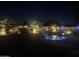 Night view of a backyard pool with rock waterfall and palm tree landscaping with accent lighting at 9662 W Sunnyslope Ln, Peoria, AZ 85345