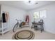 Bright bedroom with a minimalist design, featuring a desk, clothing racks, and a round rug on light carpet at 1217 N 78Th St, Scottsdale, AZ 85257