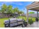 A backyard featuring a BBQ, a well-maintained lawn, and a birdcage at 12841 W W . Via Camille --, El Mirage, AZ 85335