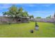 An expanse of green lawn punctuated by the birdcage, potted plants, and mature trees at 12841 W W . Via Camille --, El Mirage, AZ 85335