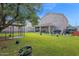A backyard featuring a covered patio, a birdcage, and a grassy lawn at 12841 W W . Via Camille --, El Mirage, AZ 85335