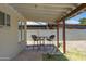 Enjoy a relaxing covered patio with a charming seating area overlooking the backyard at 2305 E Glade Ave, Mesa, AZ 85204