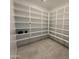 Spacious walk-in pantry providing ample storage with multiple shelves and tile flooring at 26232 N 77Th Dr, Peoria, AZ 85383