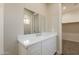 Bright bathroom features a sleek vanity and large mirror with a view to a walk-in closet at 34865 N Palm Dr, San Tan Valley, AZ 85140